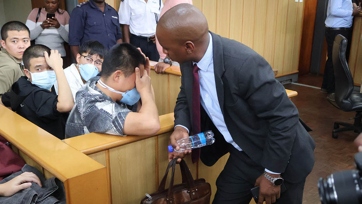 The accused persons' attorney, Linda Dlamini, having a conversation with the alleged kingpin known as 'Tiger'.