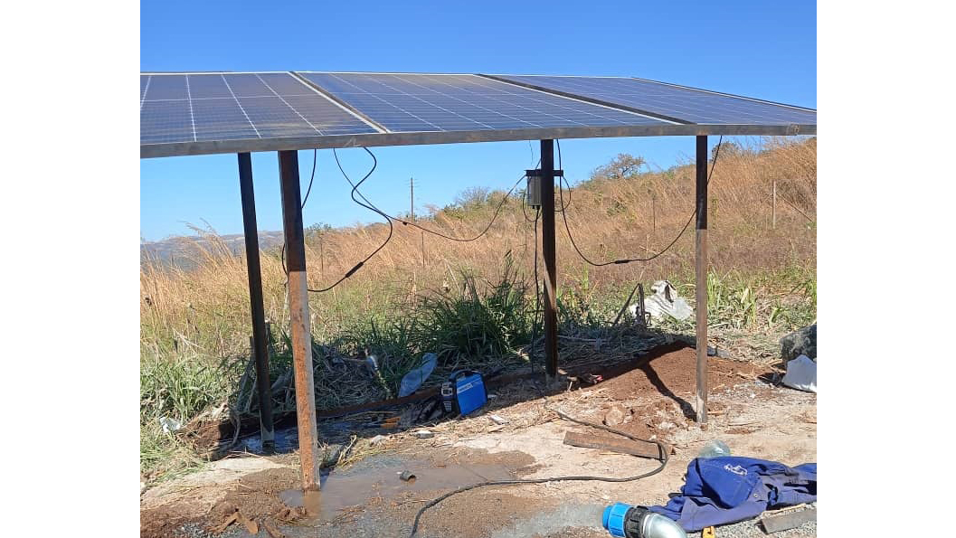 A successful solar pump installation also showing the water coming out of the pipe.